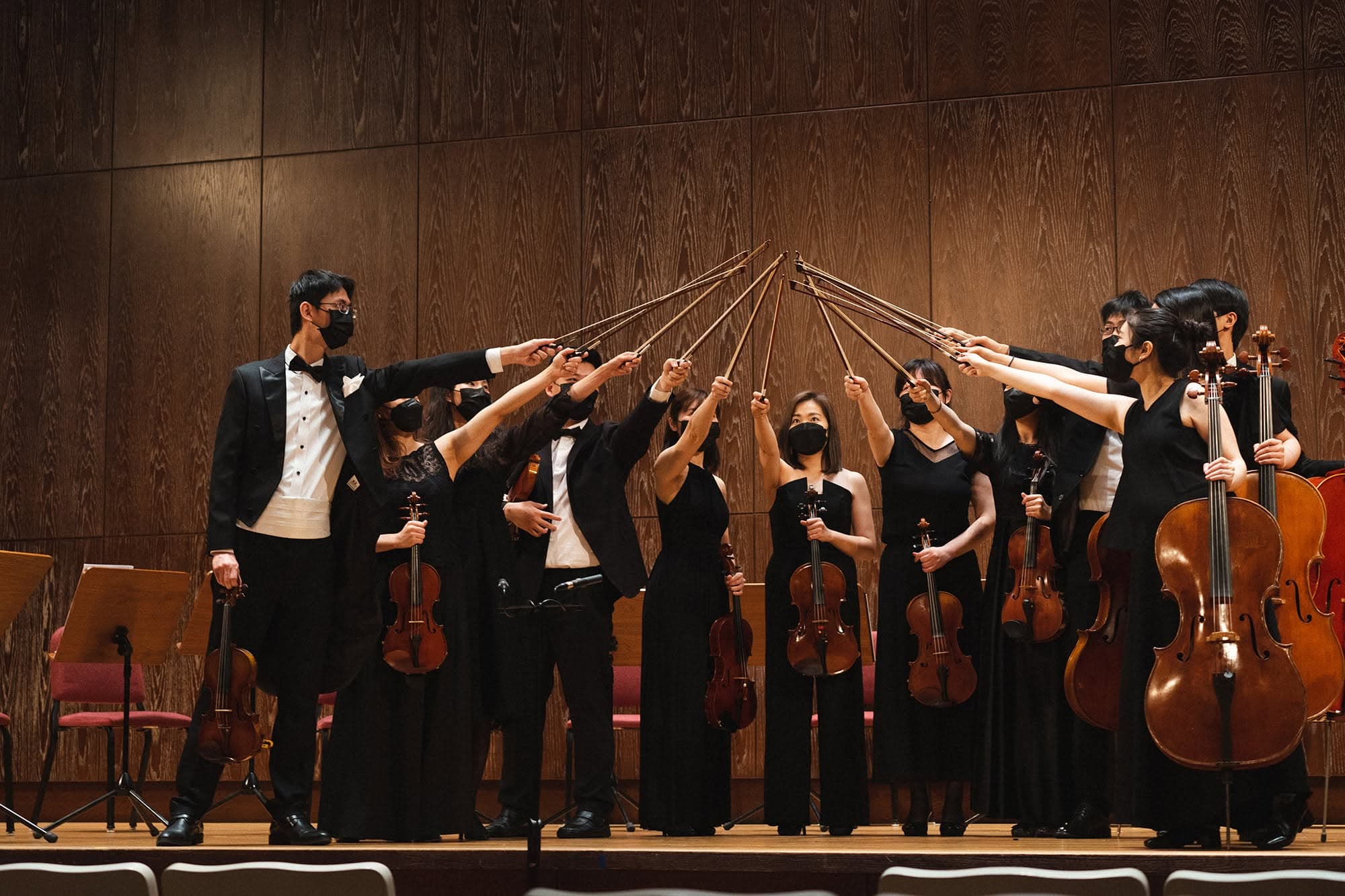 String players raise their bows together after a performance.