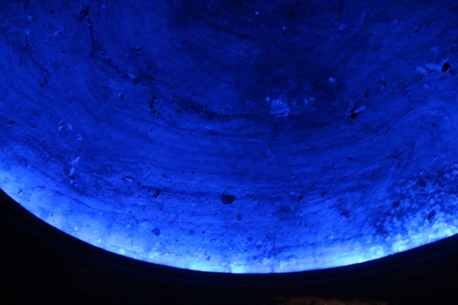 Blue light reflected across a curved stage surface.